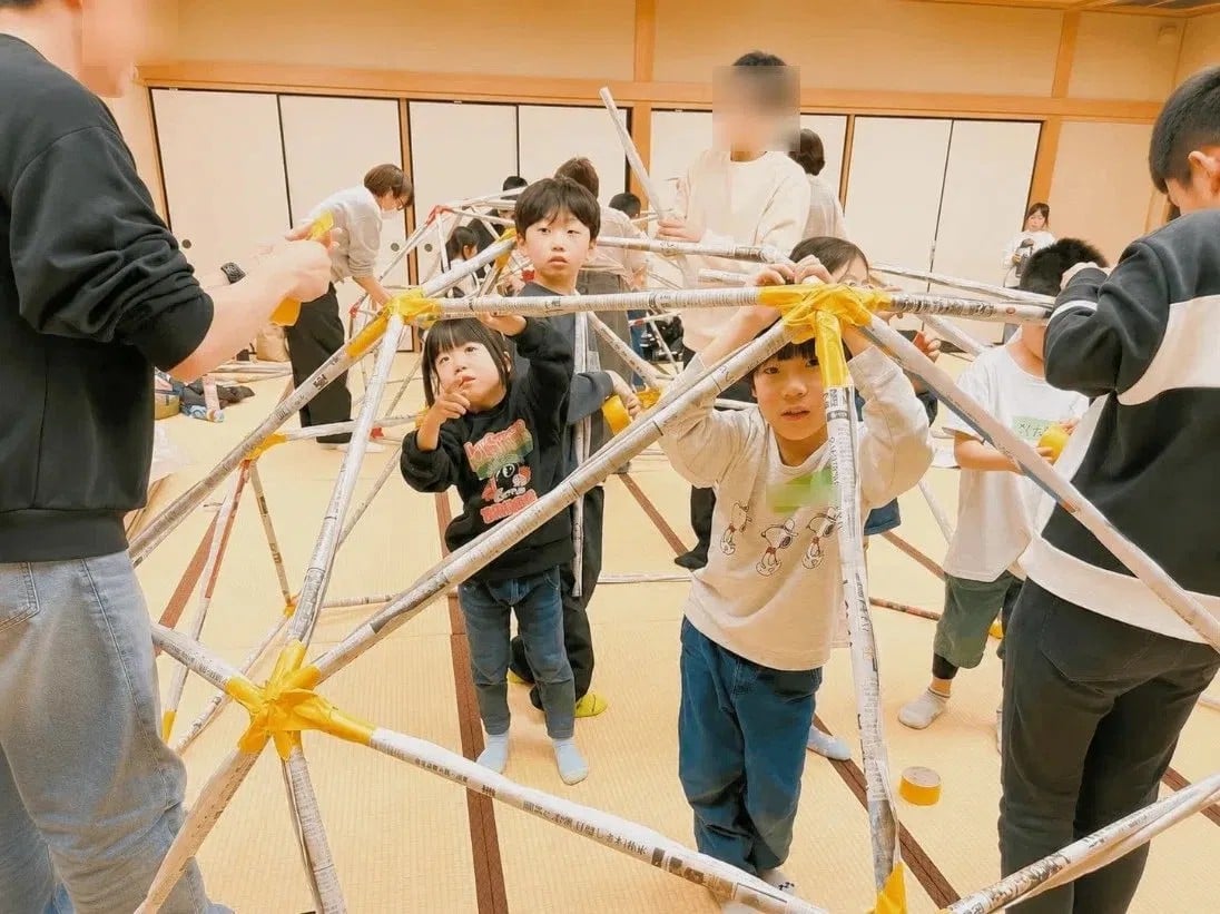 フラードームの骨組みを、力を合わせて組み立てる子どもたち