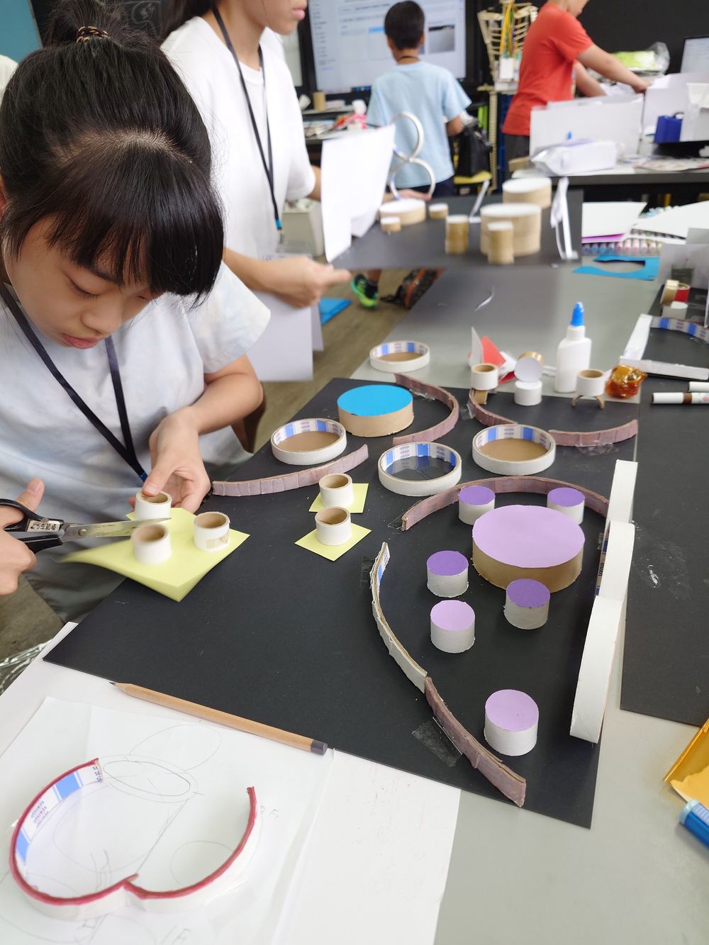 テープの芯を使って立体制作する子どもたち